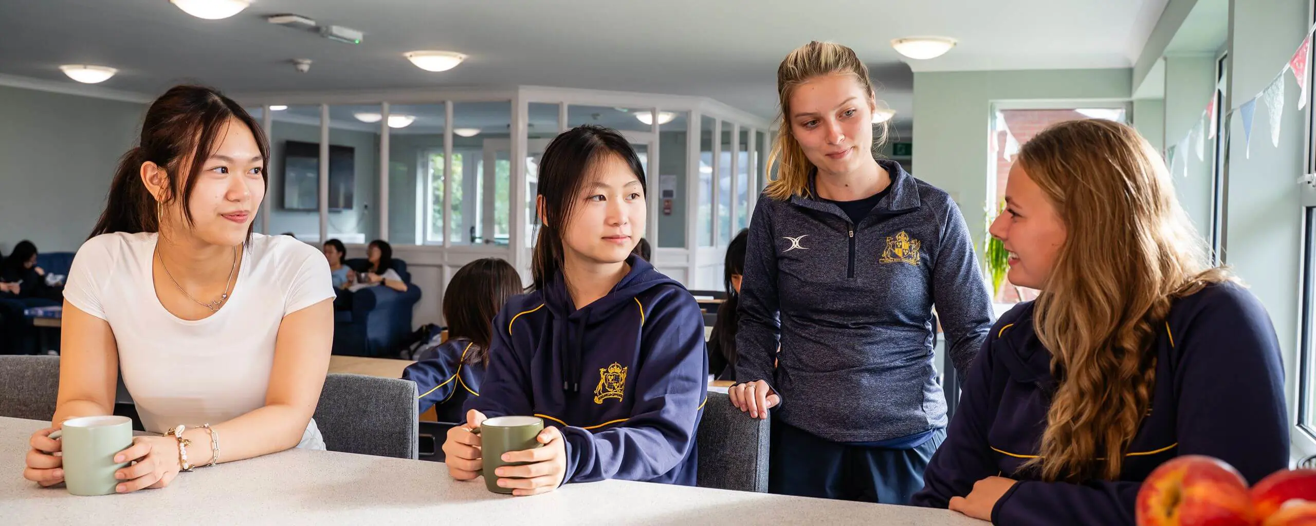 Ipswich School boarders chatting and drinking tea together.