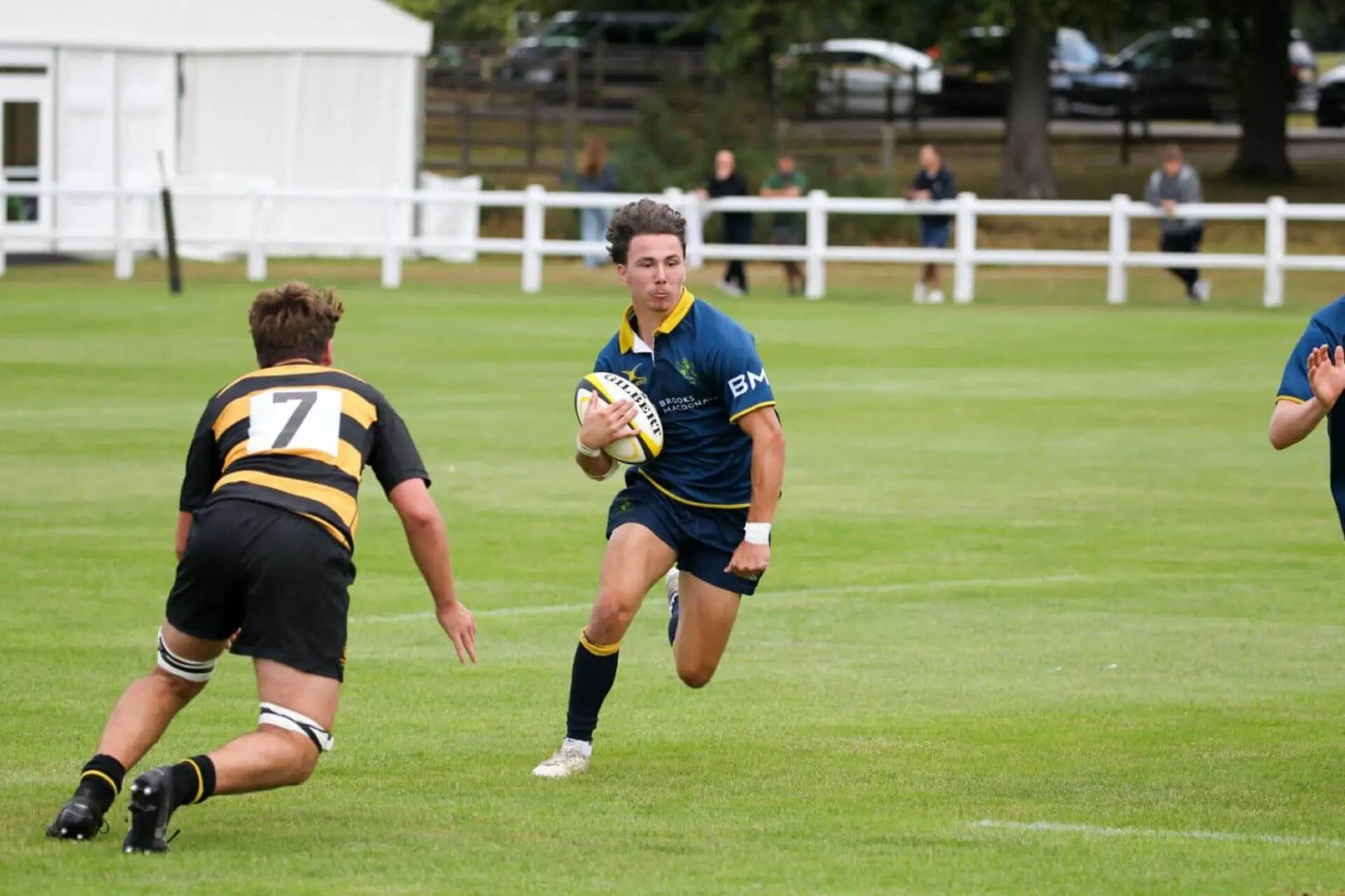 Ipswich School pupil in Brooks Macdonald sports kit playing rugby.