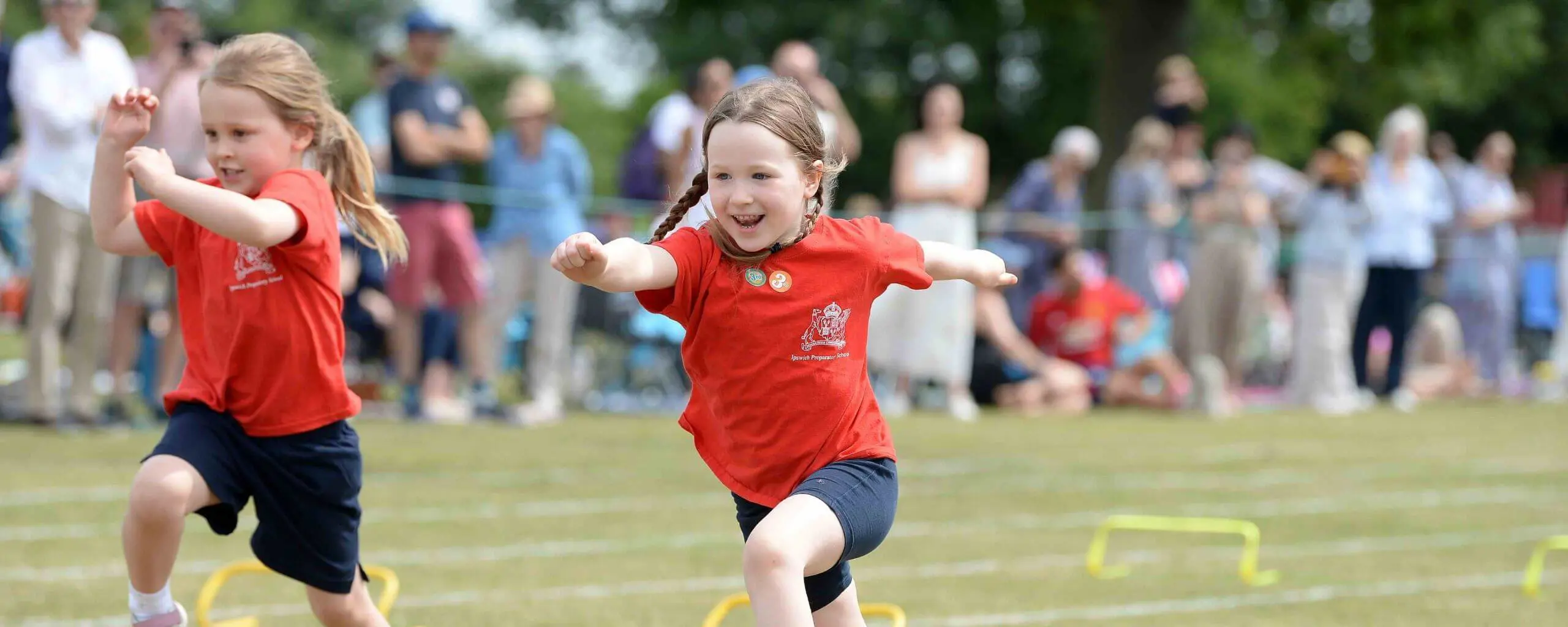 Ipswich School Prep pupils jumping over hurdles at a school sports event