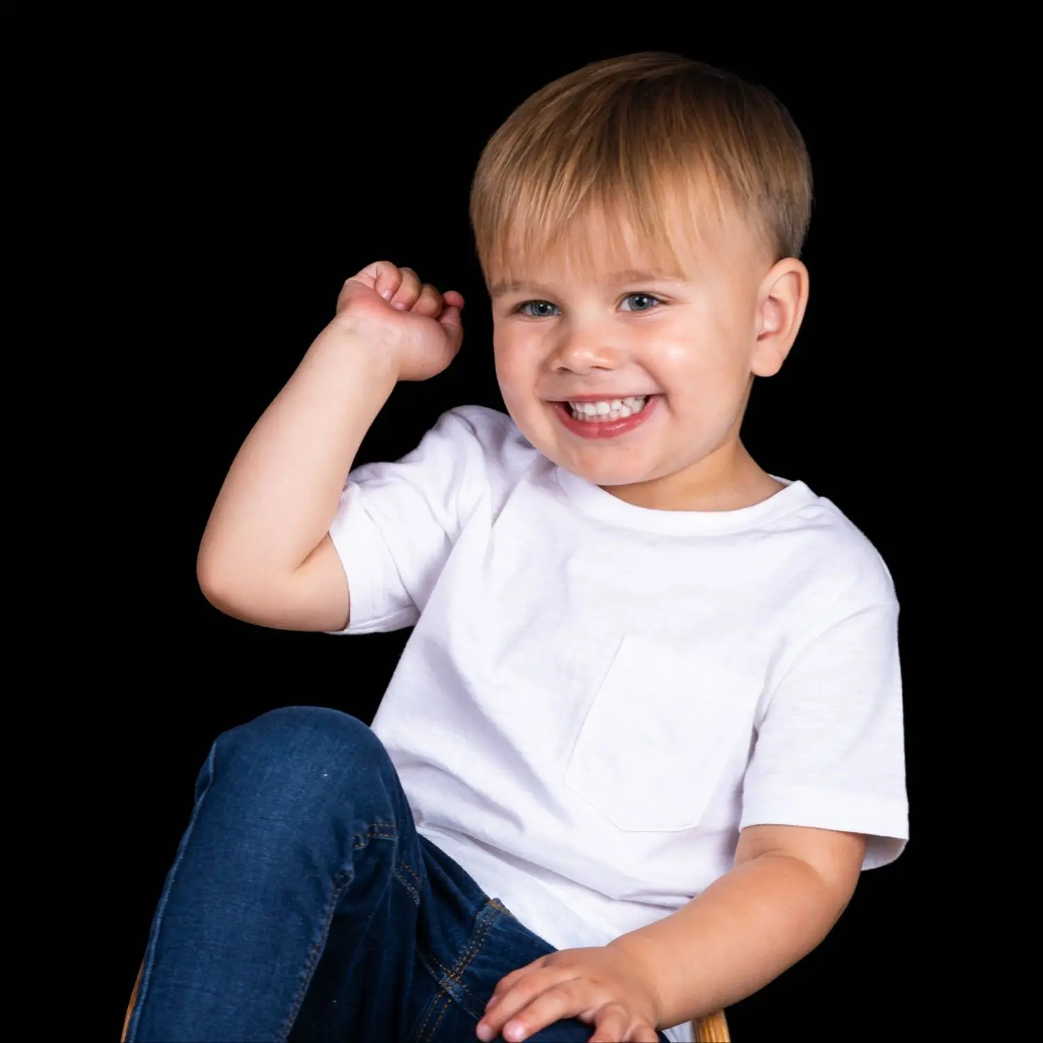 Nursery-aged boy, smiling brightly, animated and joyful, wearing a white T-shirt.